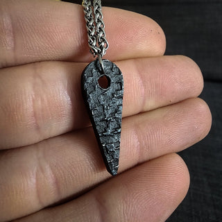 Black Tapered Stainless Steel Pendant Against Palm