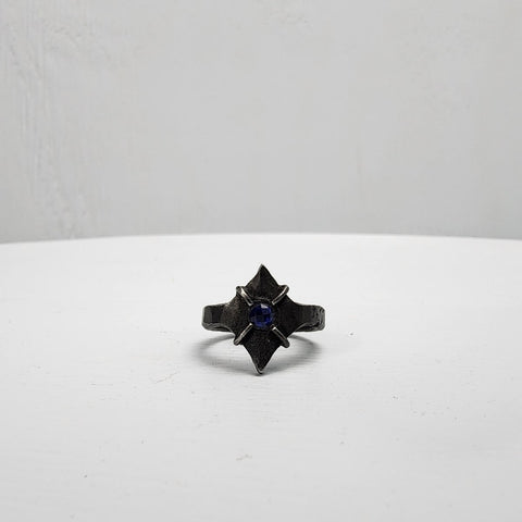 Black stainless steel star ring with a round sapphire set in the center