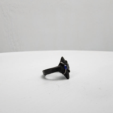 Black stainless steel star ring with a round sapphire set in the center