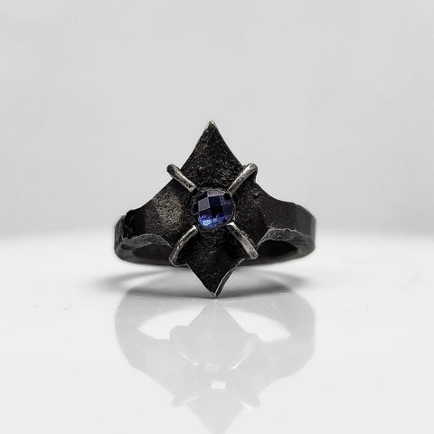 Black stainless steel star ring with a round sapphire set in the center