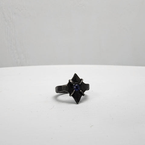 Black stainless steel star ring with a round sapphire set in the center