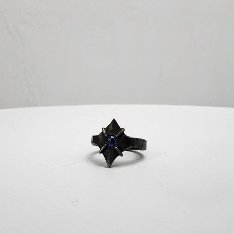 Black stainless steel star ring with a round sapphire set in the center