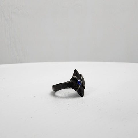 Black stainless steel star ring with a round sapphire set in the center