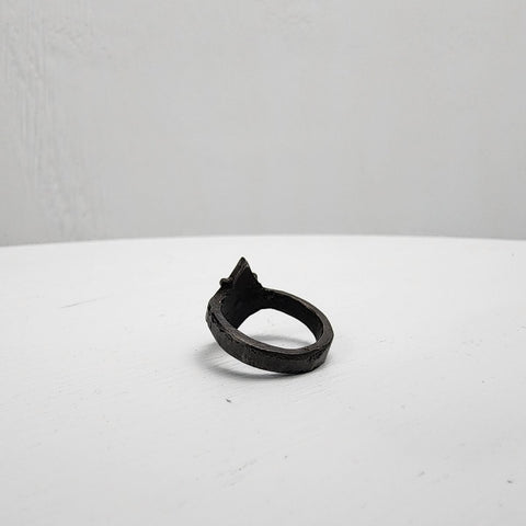 Black stainless steel star ring with a round sapphire set in the center