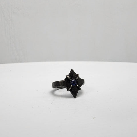 Black stainless steel star ring with a round sapphire set in the center